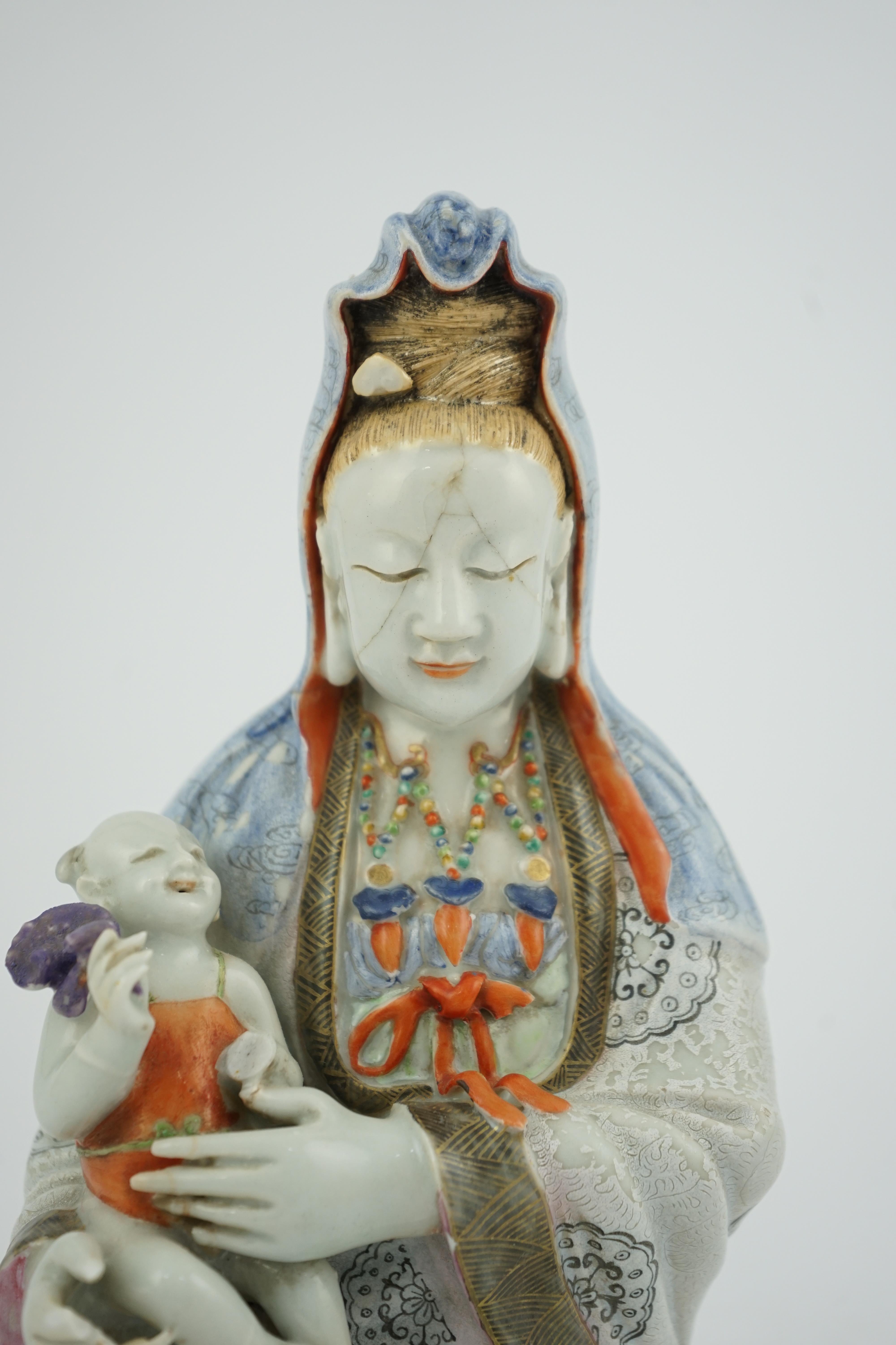 A Chinese enamelled porcelain group of Guanyin holding a child, Qianlong period